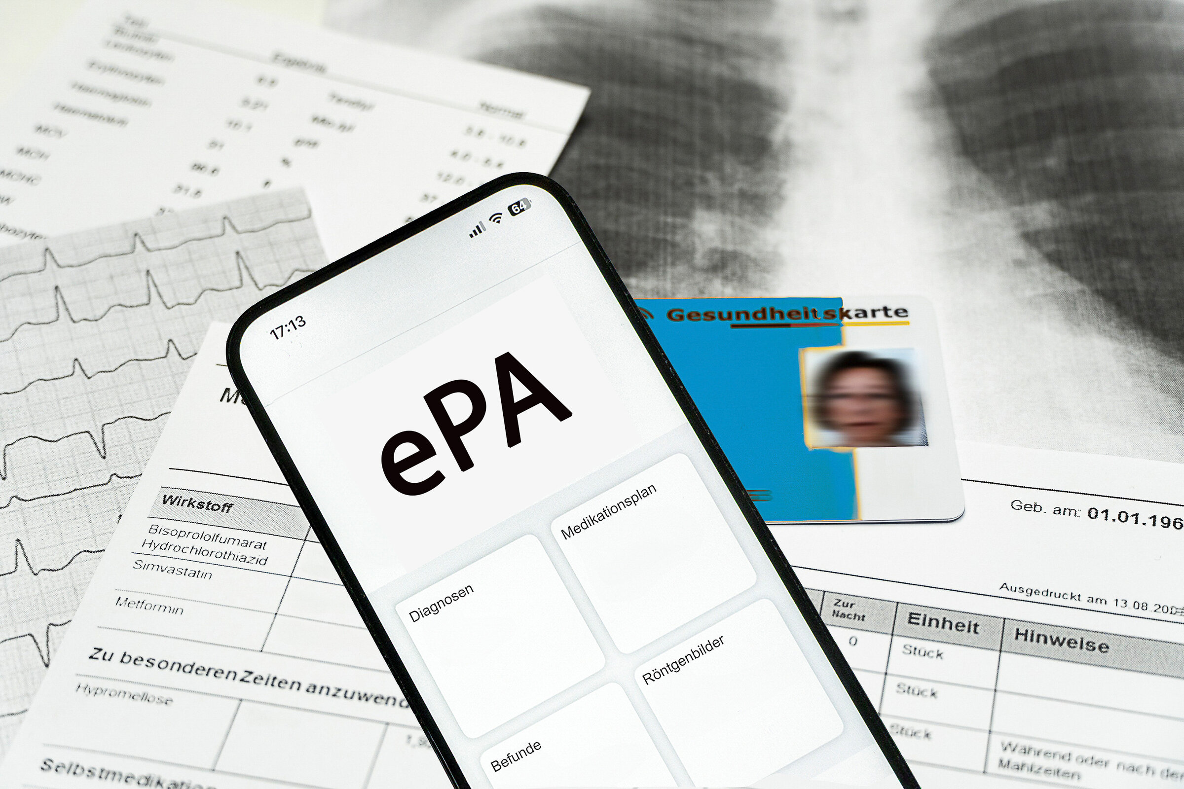 Ein Smartphone auf dem gerade eine elektronische Patientenakte angezeigt wird und eine elektronische Gesundheitskarte liegen auf medizinischen Dokumenten, horizontal AdobeStock_1038003822.jpeg